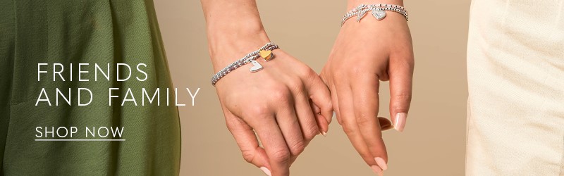image of woman wearing a friendship silver charm bracelet and matching silver necklace