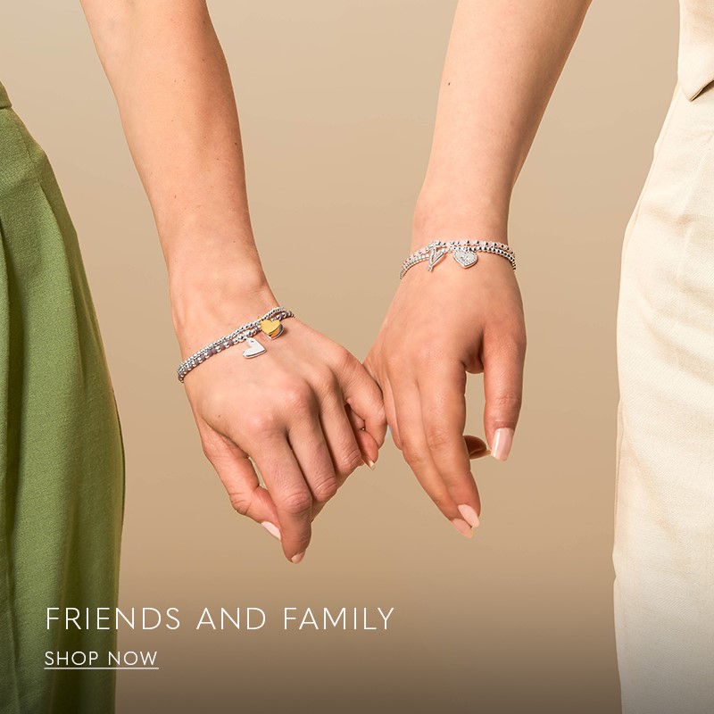 image of woman wearing a friendship silver charm bracelet and matching silver necklace